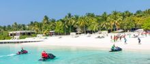 Santa arriving on jet ski in the Maldives.
