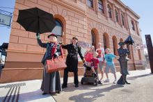 Characters dressed as Mary Poppins and Admiral Boom with tourists outside the building where Mary Poppins author P.L. Travers was born in Maryborough, Queensland.