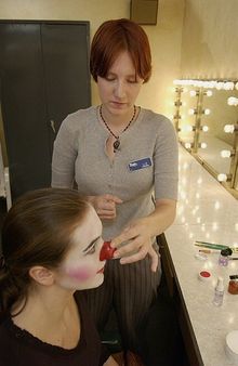 Busch Gardens Williamsburg makeup artist Liz Estella adds the finishing touch to cast member Melissa Jabaay's clown facade- a re