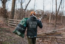 unitedbyblue.com A United By Blue volunteer hauls debris and a bag full of trash from a recent waterway cleanup. At each cleanup, trash and recycling are separated, weighed, and sent to waste management and recycling facilities to ensure proper disposal. 