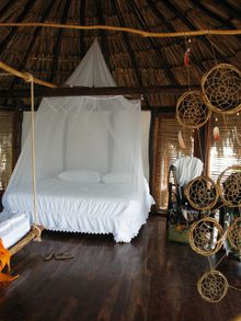 Queen size bed inside one of Azulik's cabanas