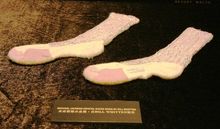 A pair of acrylic tube socks with uppers covered in alternating rows of hand-sewn Swarovski loch rosen designed by world-known c