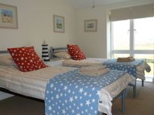 Bedroom Two Enjoys Far Reaching Rural Views.  Furnished With Twin Beds, A Bedside Cabinet And Lamp, A Wardrobe, Chest Of Drawers
