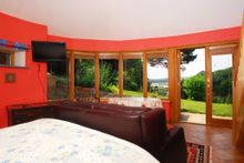 Downstairs are three beautifully finished bedrooms including the cavernous master ‘round room’ with stunning views over the tida