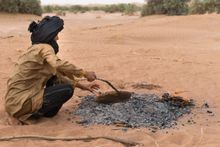 Baking fresh bread with a nomadic family in the sand beneath the embers of the campfire 