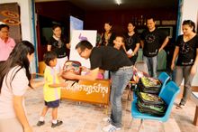Mr Indra Budiman, CEO of Hansar Hotels & Resorts presenting a bag to one of the pupils