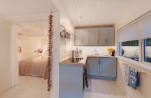 Opening onto the living room is the well equipped kitchen and dining area featuring an attractive distressed dining table and ch