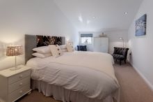 The master bedroom in Merchants Rest has a large queen-size bed with bathroom next door, and the single bedroom beyond.