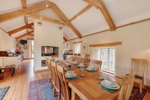 Coombe Farm has a large dining room with an open fireplace, seating for twelve, views of the lower gardens and access to the upp