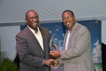 Chairman Of The Board, Alfonso O'Garro Presents The Award Of Excellence To The St. Christopher Air And Sea Ports Authority, Whi
