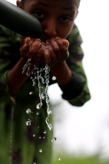 A young girl makes the most of a CARE-supported water pump in Kanat Kebele village, South Gondar, Ethiopia