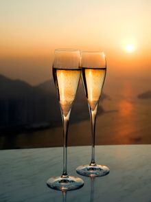 Sunset views of Victoria Harbour with a glass of wine at Café 100 by the Ritz-Carlton, Hong Kong