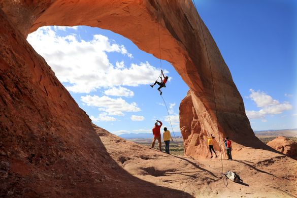 01_Wilson’s Arch – Climber Miranda Oakley dangles delicately under Wilson’s Arch in Moab, Utah.