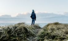 A Danish boy with a camera in the dune heath landscape near Klitmøller on the west coast of Denmark. 