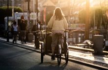 A woman riding a cargo bike in Nyhavn.
