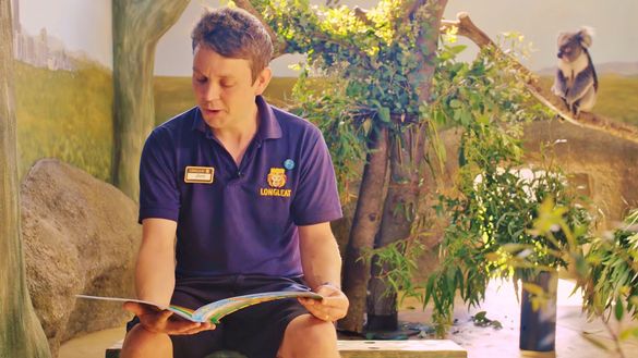 Longleat keeper Jon Ovens reads storybook with koala in backgrund