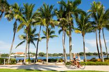 Bike riding along the intracoastal in West Palm Beach with Palm Beach on the other side of the water.