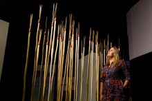 Curator Shona Coyne with fishing spears made by the Dharawal community, similar to three in the exhibition taken by Captain Cook in 1770.
