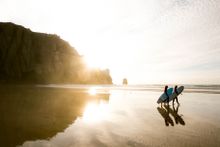 Surfers walking to the sea on a beautiful Cornish beach