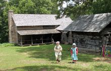 Girls dressed in period attire make their way across the grounds of Historic Collinsville.