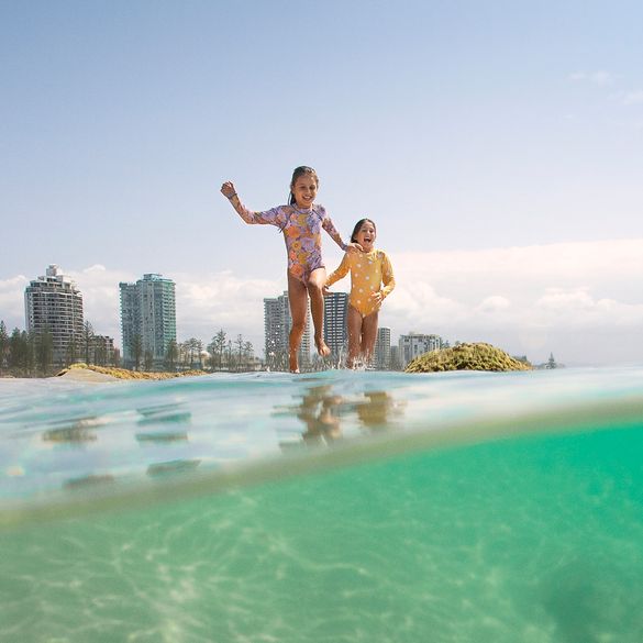 Kids running into the water at Rainbow Bay