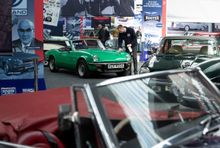 A member of staff polishes one of the cars in the Great British Car Journey exhibition