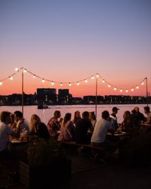 Groups of friends enjoying a meal and drinks at the Reffen Street Food Market  on a late summer evening.