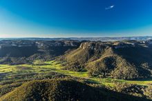 Aerial of Wolgan Valley surrounded by the World-Heritage listed Gardens of Stone National Park, Blue Mountains.