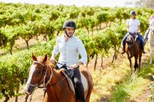 Couple enjoying a guided horseback tour at Hanging Tree Wines, Pokolbin with Murchessons Horse Wine & Dine Tours.