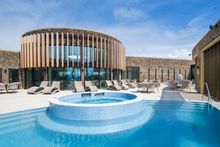 Outdoor heated sunset spa encircled by an edge pool in the Aqua Club