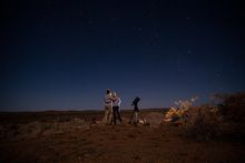 Couple star gazing beneath the Milky Way at Outback Astronomy, Broken Hill.