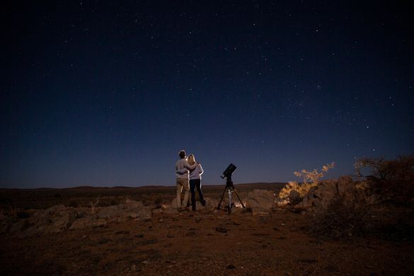 Couple star gazing beneath the Milky Way at Outback Astronomy, Broken Hill.