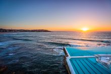 Morning sun rising over Bondi Icebergs, Bondi Beach.