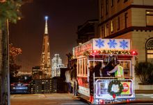 Cable car with view of Transamerica building at night. 