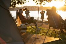 Family relaxing and enjoying their stay at Cockatoo Island's waterfront campground.