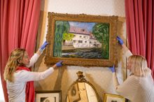 Zuleika Gallery's founder director Lizzie Collins left and Blenheim Palace's Kate Ballenger hang The Mill at St Georges-Motel, c. 1930 by Sir Winston Churchill
