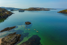 Pictured above: A group Stand Up Paddleboarding at Ganavan Bay, Oban