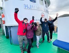 A group of guests on board the Hjalmar Bjørge, excited for their wildlife adventure cruise.