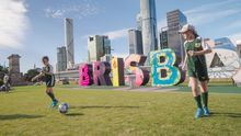 Young football fans mark the 100 day countdown to the FIFA Women's World Cup 2023 by kicking a ball around the Brisbane sign. Brisbane is one of the host cities for the event