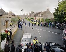 David Cameron leaves the local polling station in Spelsbury in Oxfordshire, holding hands with his wife Samantha. A polite and restrained media circus litters the street while extended microphone booms attempt to capture Cameron's comments. In the crowd i
