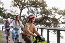 Family enjoying a ride through the Royal Botanic Garden Sydney on their hired bicycles from Bonza Bike Tours