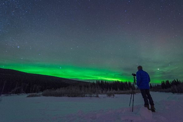 Person photographing the northern lights outside Fairbanks, Alaska. 