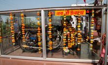 Photograph of Pali Bullet Baba Motorcycle temple with a motorcyle behind glass doors