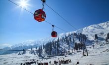 Photo of a red cable car travelling through the mountains in Gulmarg, Kashmir