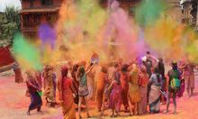 Photo of Holi celebrations taking place and colourful powder being thrown into the air