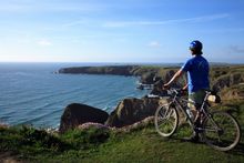 Cyclist at Bedruthan Steps in Cornwall