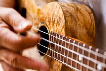  Close up of ‘ukulele strumming.