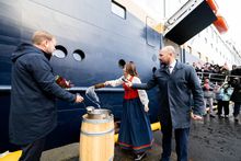 The godmother of Havila Polaris throws water at the ship to name it. 