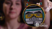 An Alaska Native beader, Jill, shows off her beadwork.