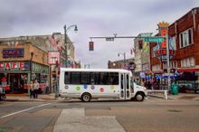 Tour shuttle bus driving through intersection of 2nd and Beale Street in Memphis.